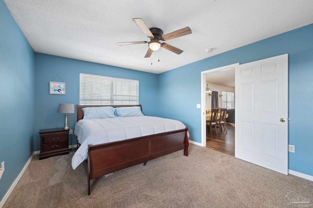 bedroom with a textured ceiling, carpet floors, and ceiling fan