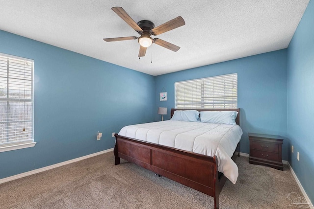 carpeted bedroom with ceiling fan and a textured ceiling