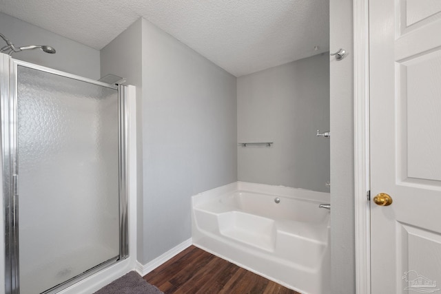 bathroom with hardwood / wood-style flooring, shower with separate bathtub, and a textured ceiling