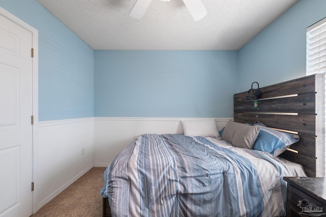 bedroom featuring a textured ceiling, ceiling fan, and carpet flooring