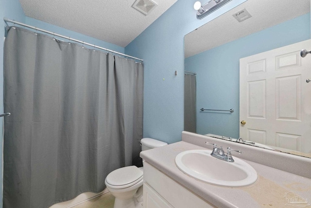 bathroom featuring vanity, toilet, and a textured ceiling