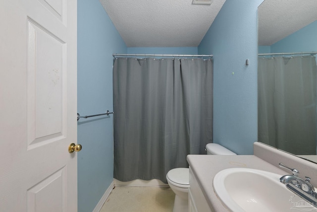 bathroom featuring vanity, toilet, curtained shower, and a textured ceiling