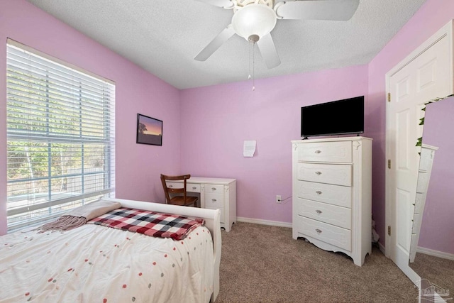 bedroom with multiple windows, light carpet, a textured ceiling, and ceiling fan