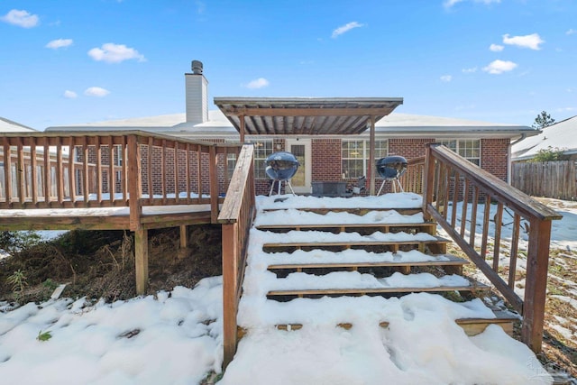 snow covered deck with a grill