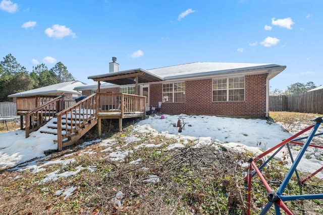 snow covered house featuring a wooden deck