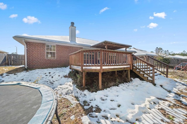 snow covered house with a wooden deck