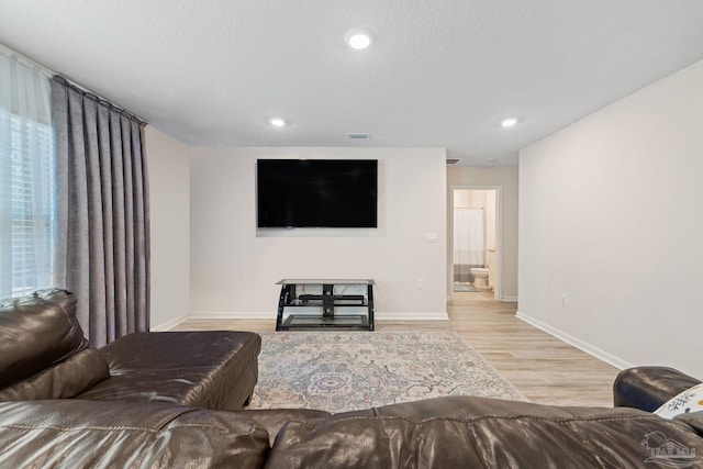 living room featuring light wood-type flooring and a textured ceiling