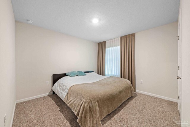 carpeted bedroom with a textured ceiling