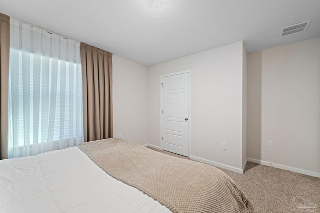 carpeted bedroom featuring a textured ceiling