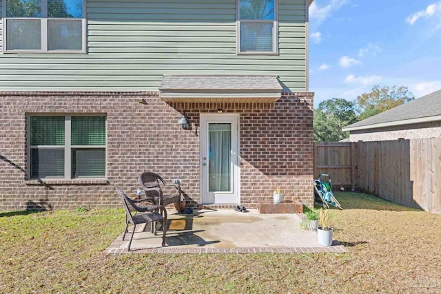 rear view of house featuring a lawn and a patio