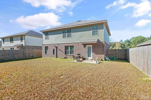 rear view of property featuring a patio area and a yard