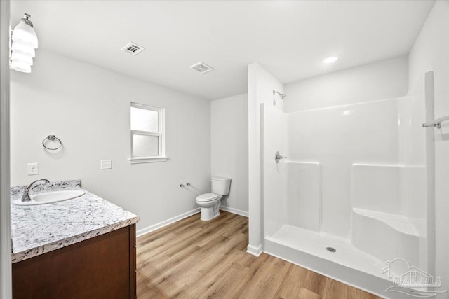 5621 Kingery Rd, Milton, FL 32583 - full bath featuring wood finished floors, walk in shower, toilet, baseboards, and vanity