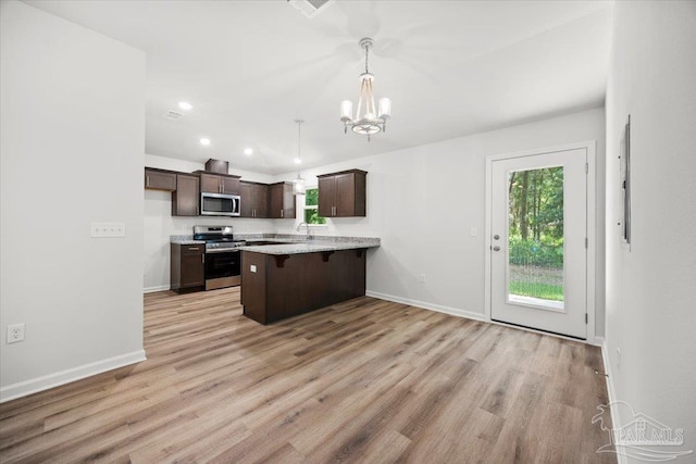 5621 Kingery Rd, Milton, FL 32583 - kitchen with stainless steel appliances, dark brown cabinetry, a peninsula, healthy amount of natural light, and recessed lighting