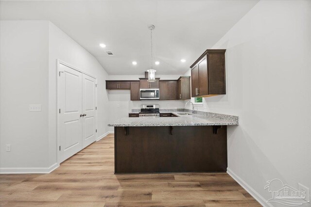 5621 Kingery Rd, Milton, FL 32583 - kitchen with stainless steel appliances, dark brown cabinetry, a sink, a peninsula, and light stone countertops