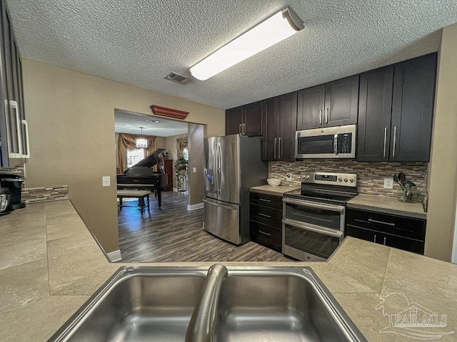 kitchen with decorative backsplash, appliances with stainless steel finishes, and sink