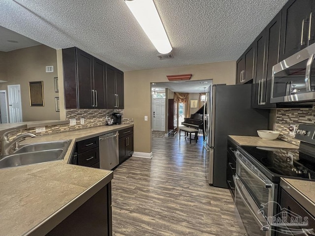 kitchen with backsplash, hardwood / wood-style flooring, sink, and appliances with stainless steel finishes