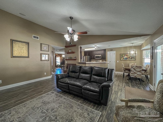 living room featuring a textured ceiling, ceiling fan with notable chandelier, lofted ceiling, and dark wood-type flooring