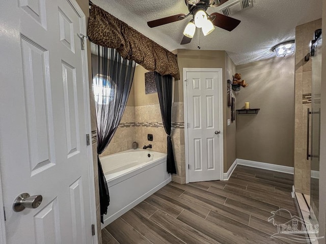 bathroom with shower / bathing tub combination, a textured ceiling, and ceiling fan