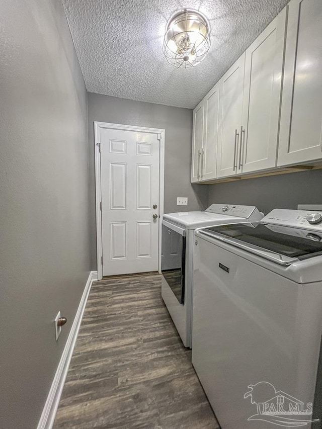 laundry room featuring dark hardwood / wood-style flooring, cabinets, separate washer and dryer, and a textured ceiling