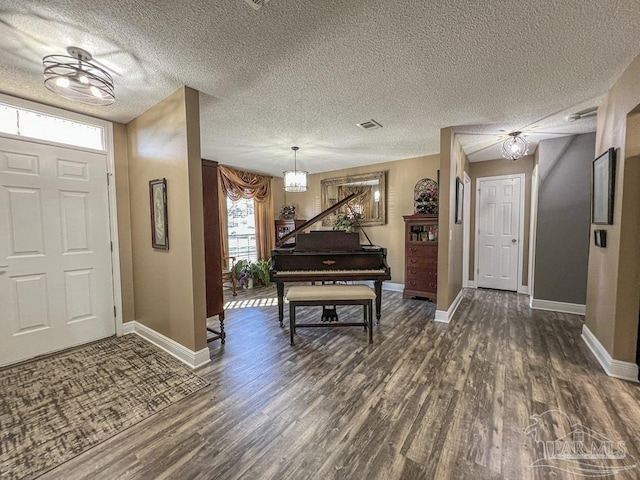 entryway featuring dark hardwood / wood-style flooring, a textured ceiling, and an inviting chandelier