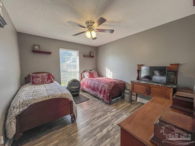 bedroom with hardwood / wood-style flooring, ceiling fan, and a textured ceiling