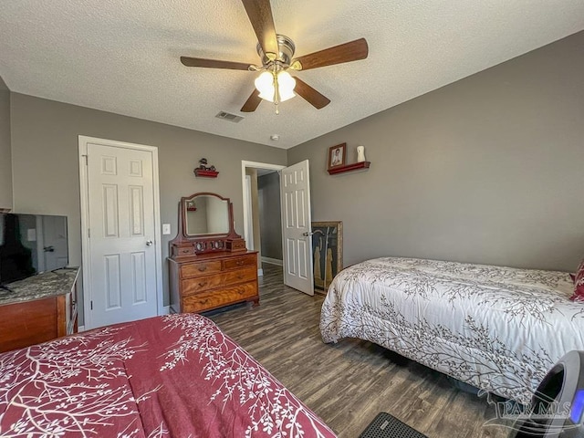 bedroom with a textured ceiling, dark hardwood / wood-style floors, and ceiling fan