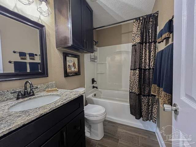 full bathroom featuring vanity, shower / bath combo, a textured ceiling, and toilet