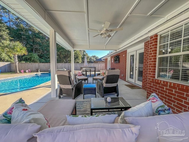 view of patio / terrace with a fenced in pool, ceiling fan, french doors, and an outdoor hangout area