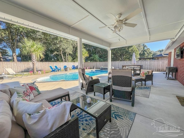 view of patio / terrace featuring a fenced in pool, an outdoor living space, and ceiling fan