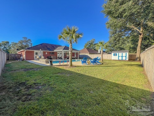 view of yard featuring a patio area, a fenced in pool, and a storage shed