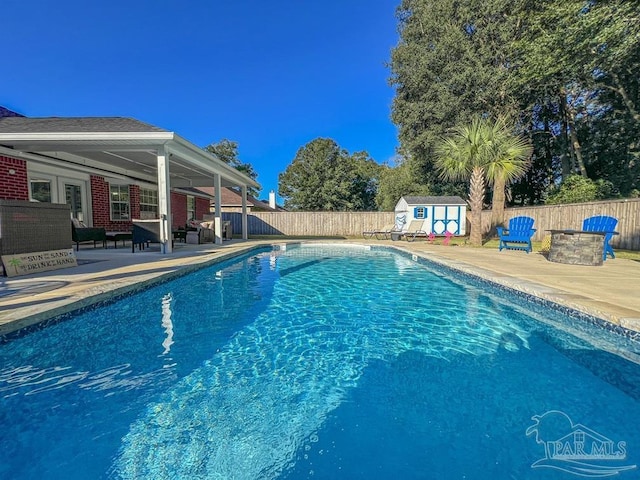 view of pool with a patio and a storage shed