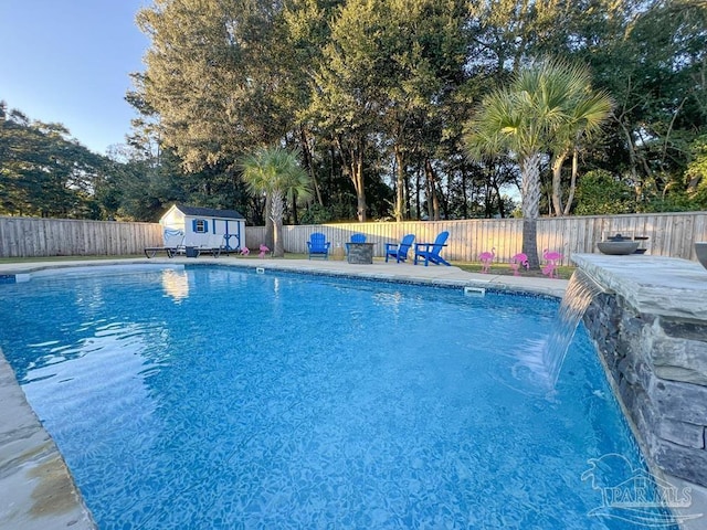 view of swimming pool featuring pool water feature and a shed