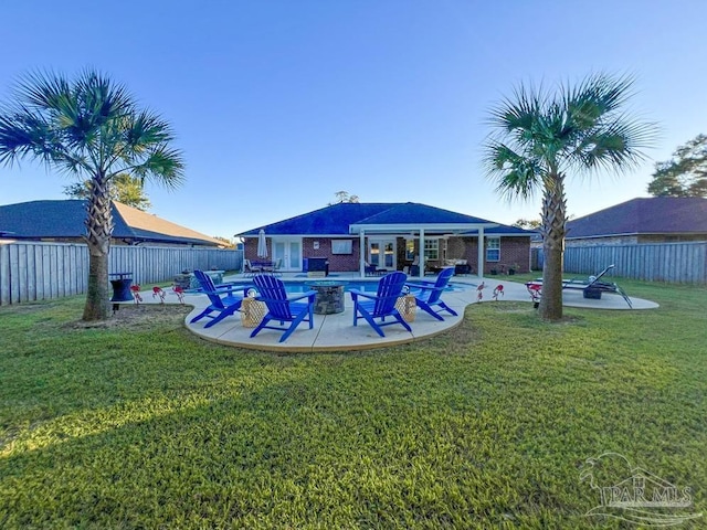 view of swimming pool with a fire pit, a patio area, and a lawn