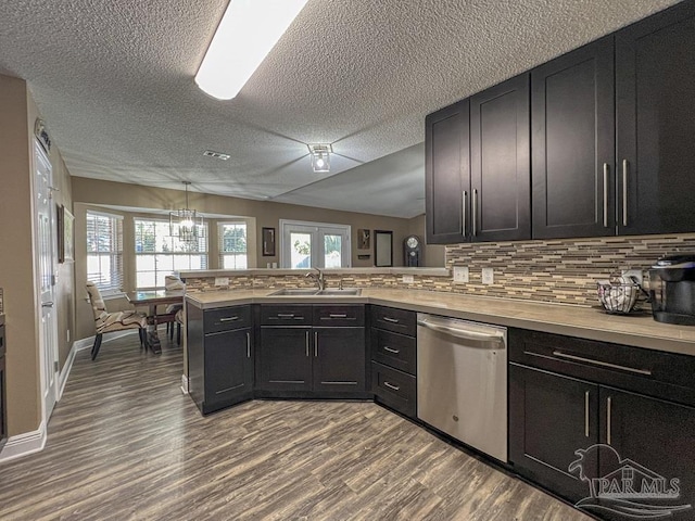 kitchen featuring kitchen peninsula, backsplash, stainless steel dishwasher, and sink