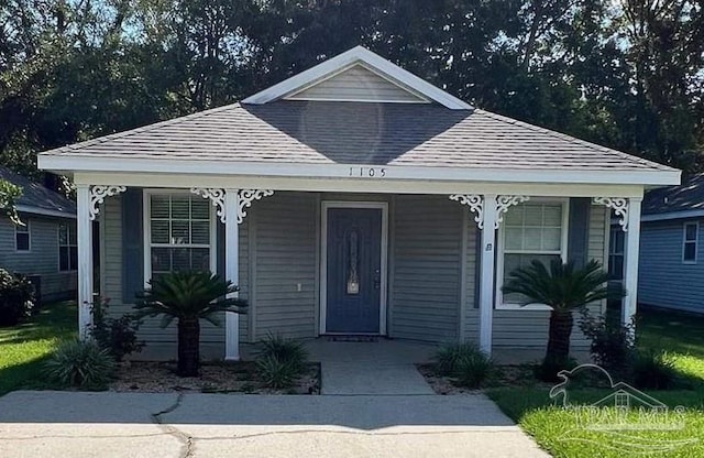 view of front facade with a porch and roof with shingles