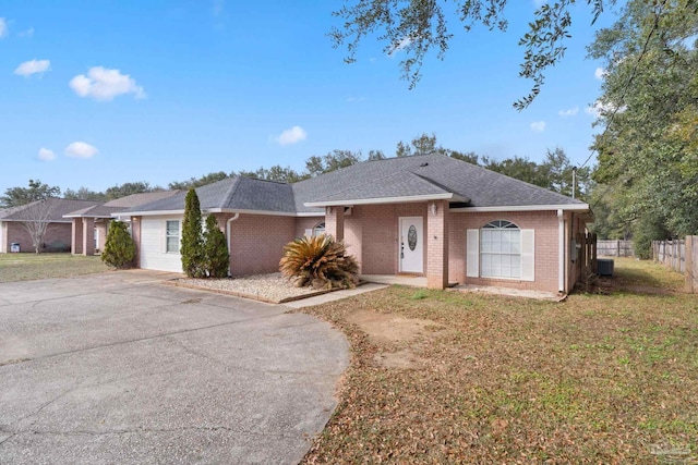 single story home featuring cooling unit and a front yard