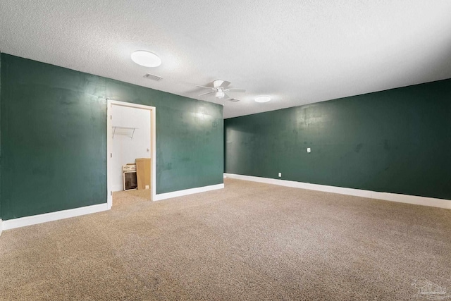 spare room featuring carpet floors, a textured ceiling, and ceiling fan