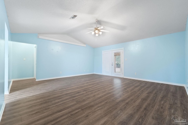 spare room with dark hardwood / wood-style flooring, a textured ceiling, vaulted ceiling, and ceiling fan