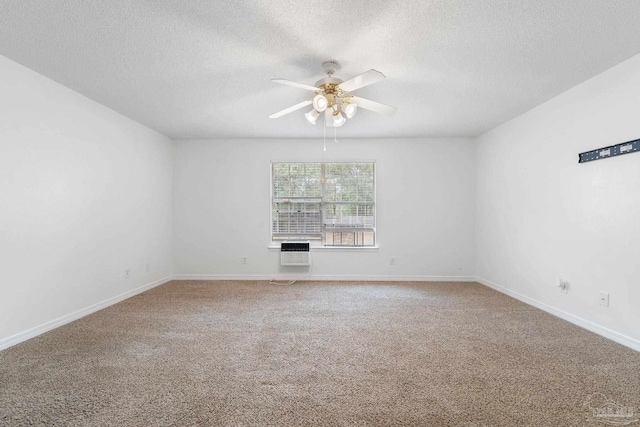 unfurnished room featuring a textured ceiling, an AC wall unit, ceiling fan, and carpet flooring