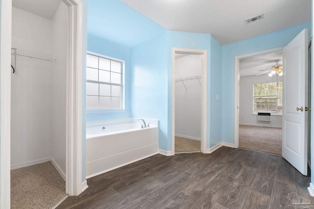 bathroom featuring hardwood / wood-style flooring and a tub to relax in