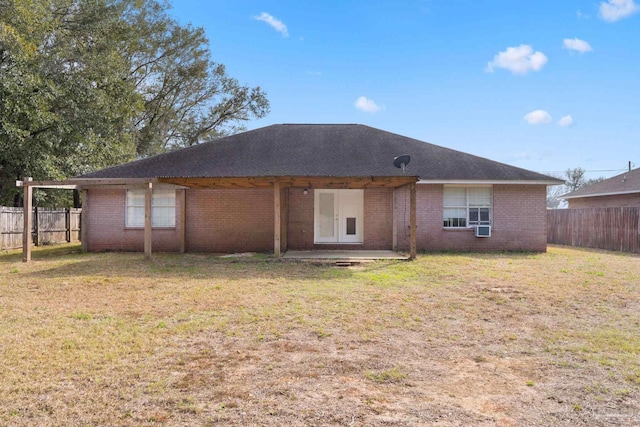 rear view of property featuring a lawn