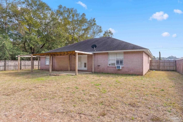 rear view of property with cooling unit and a lawn