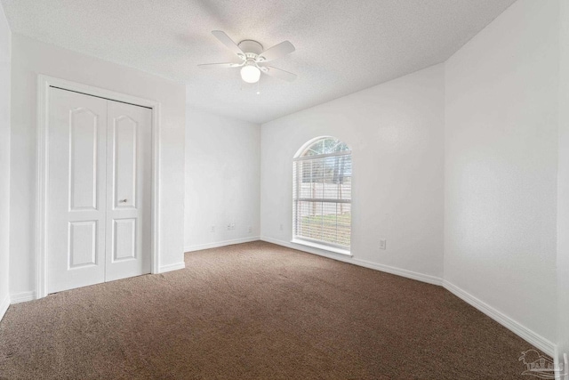 unfurnished bedroom with ceiling fan, carpet, a textured ceiling, and a closet