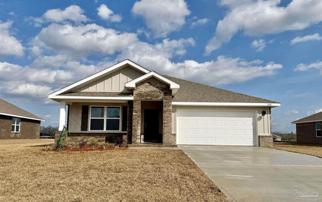 2698 Chevy Cir, Pace, FL 32571 - view of front of home featuring board and batten siding, concrete driveway, a garage, and a front yard