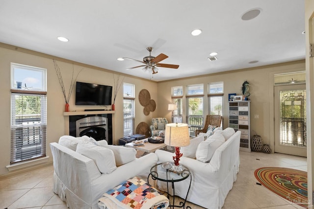 tiled living room featuring ceiling fan and ornamental molding