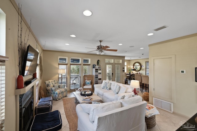 tiled living room featuring ceiling fan and crown molding