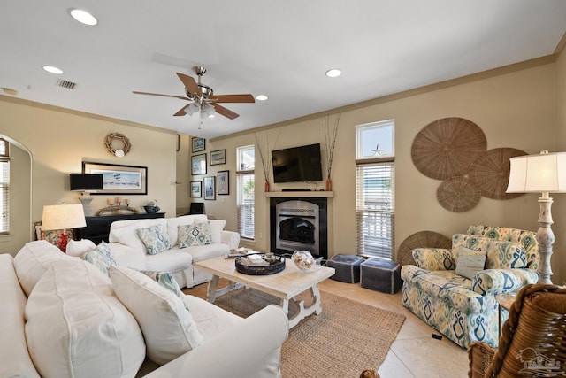 living room featuring ceiling fan, light tile patterned flooring, and crown molding