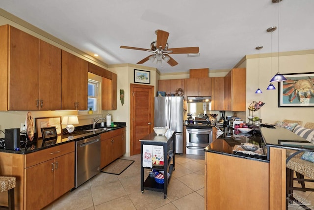 kitchen with light tile patterned floors, appliances with stainless steel finishes, a kitchen island, pendant lighting, and sink