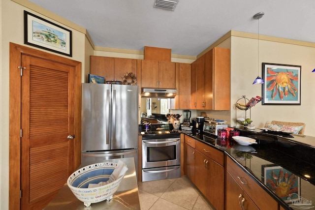 kitchen with hanging light fixtures, light tile patterned floors, appliances with stainless steel finishes, and dark stone countertops