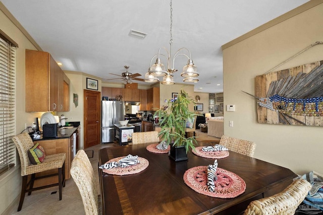 dining space featuring light tile patterned floors, sink, and ceiling fan with notable chandelier